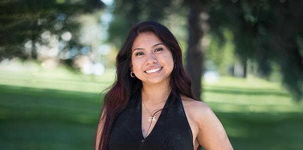 Portrait of Arely Patricio on campus with a green background